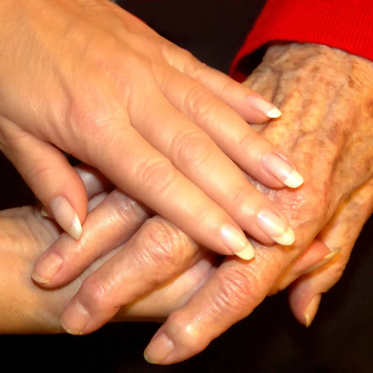 Symbolbild für Zuwendung und Geborgenheit in der Seniorenbetreuung Zwei helfende Hände legen sich behutsam um die Hand einer älteren Person – Nahaufnahme als Symbol für Fürsorge, Vertrauen, menschliche Nähe